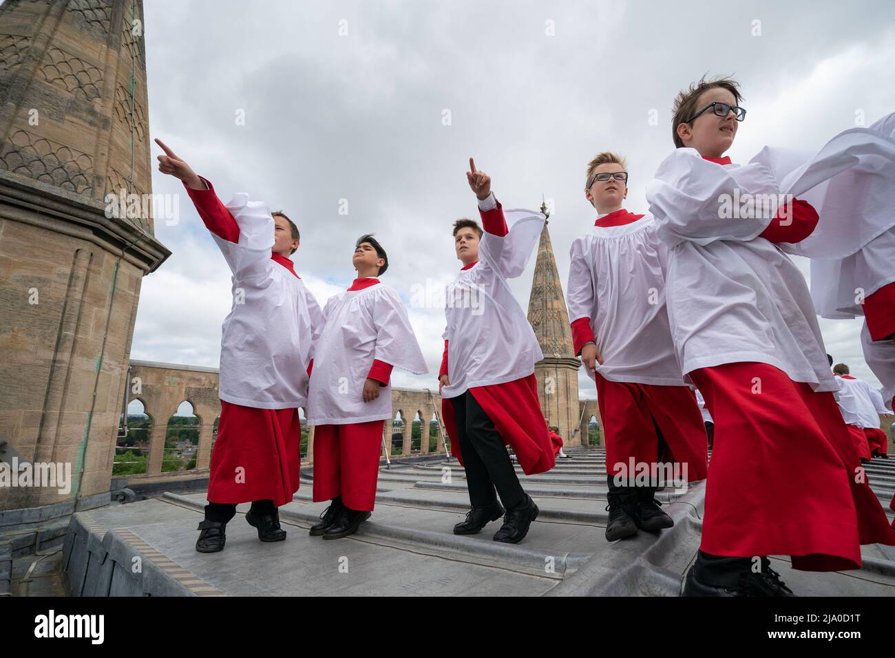 Choristers from the Choir of St John's College, Cambridge, take in the view before performing the Ascension Day carol from the top of the Chapel Tower at St John's College, a custom dating back to 1902. Picture date: Thursday May 26, 2022. Every year on Ascension Day the Choir ascends the 163ft Chapel Tower and sings the Ascension Day carol. This custom dates from 1902 and was begun by the then Director of Music, Cyril Rootham, following a conversation with Sir Joseph Larmor. Sir Jospeh was insistent that a choir singing from the tower would not be heard from the ground. Rootham was keen to pr Stock Photo