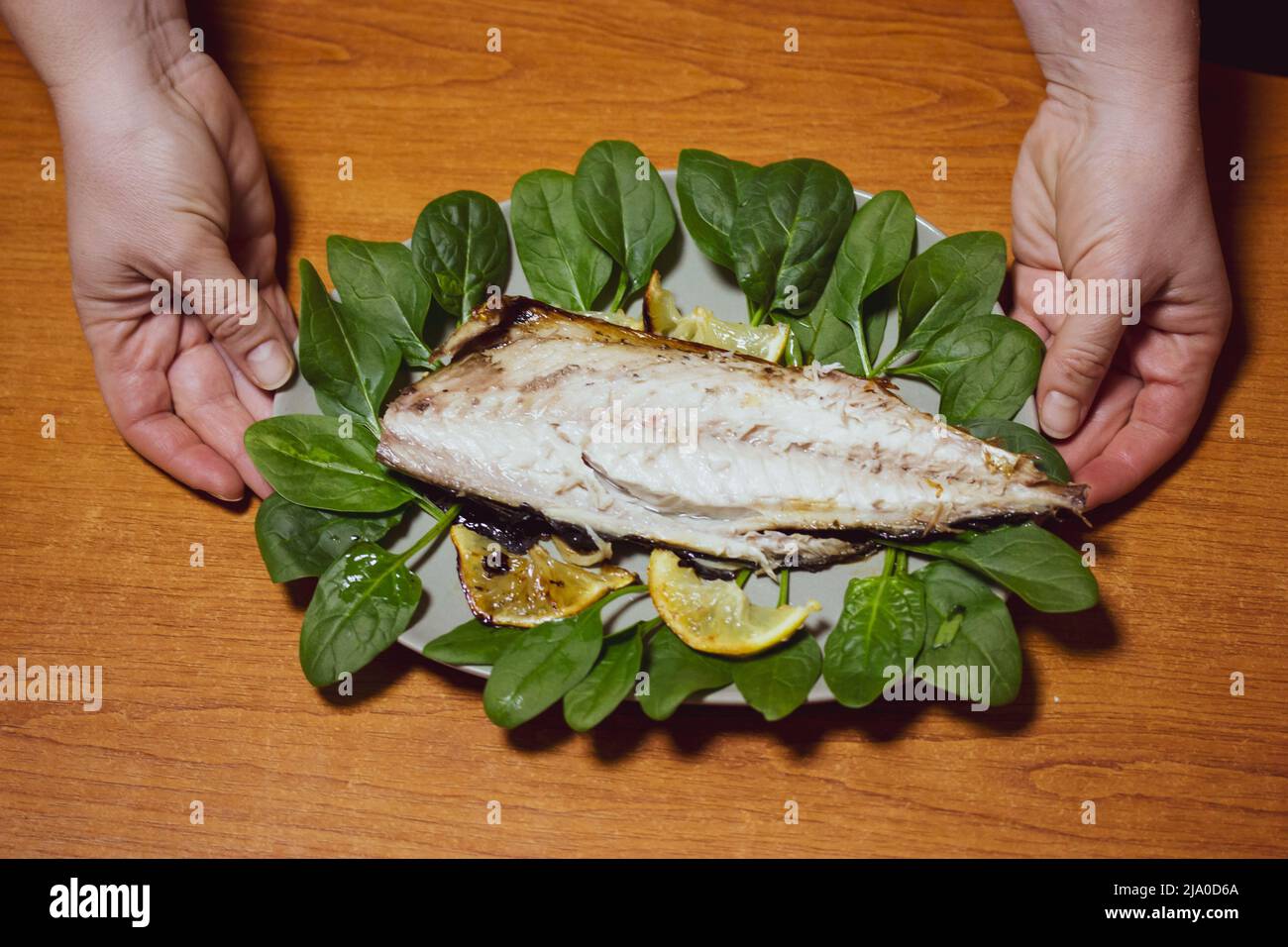 Plate, dish of oven baked white freshwater fish with lettuce leaves in ...