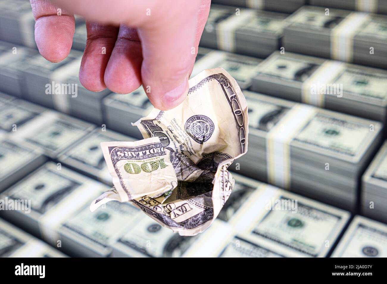 A crumpled hundred-dollar bill in his hand. The world economy no longer believes in the reliability of the dollar Stock Photo
