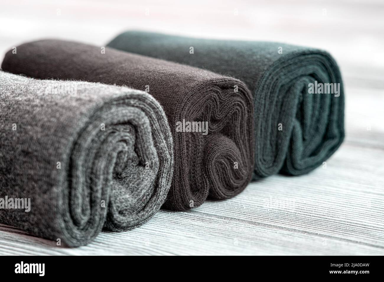 A set of gray, blue and black socks, rolled up for storage Stock Photo