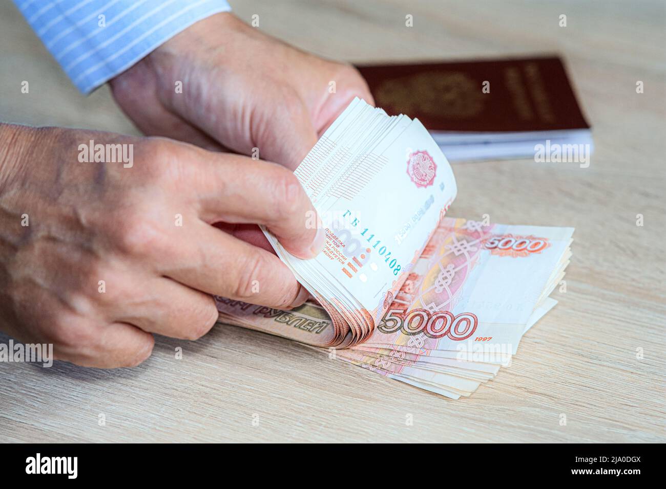 A woman's hand with money in the window cash register. The concept of currency exchange. The hand gives cash and the hands receive cash. The day of pa Stock Photo