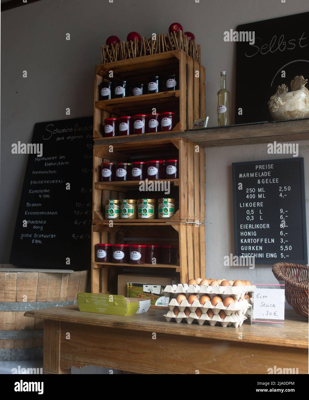 Shelf made of wooden boxes eggs in egg carton Price list Farm shop farm with lots of jam jars Stock Photo