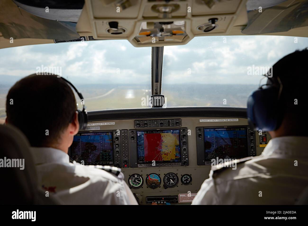 Two pilots on a small charter plane flight landing at the Arusha airport, Tanzania, Africa. Stock Photo