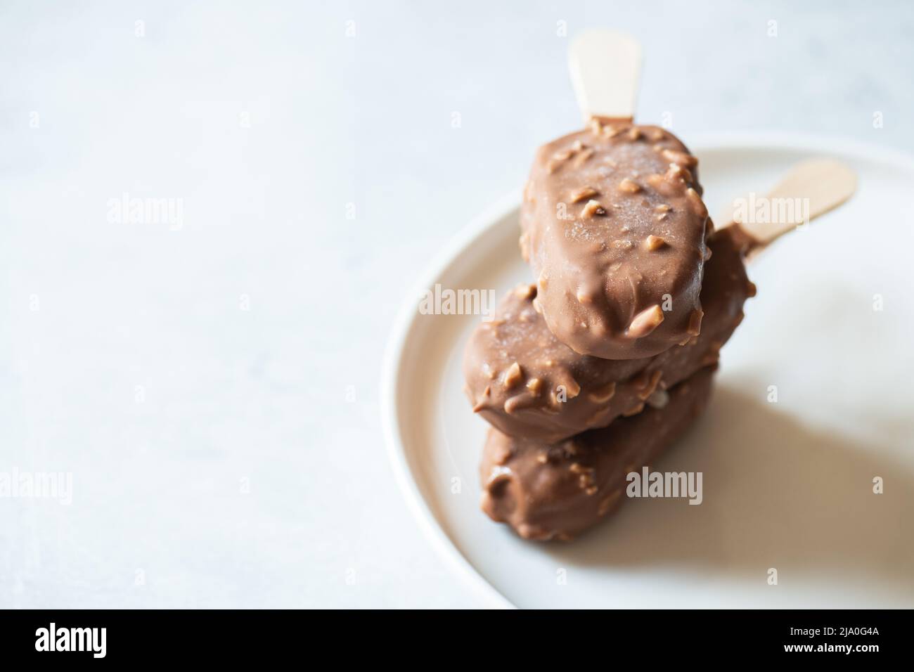 Almond chocolate ice-cream on a stick. Close up. Stock Photo