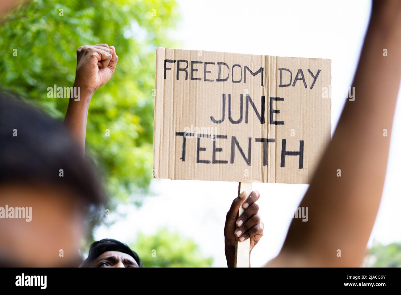 concept of Juneteenth freedom day march showing by close up protesting hands sign board - concept of activism, justice and demonstration Stock Photo