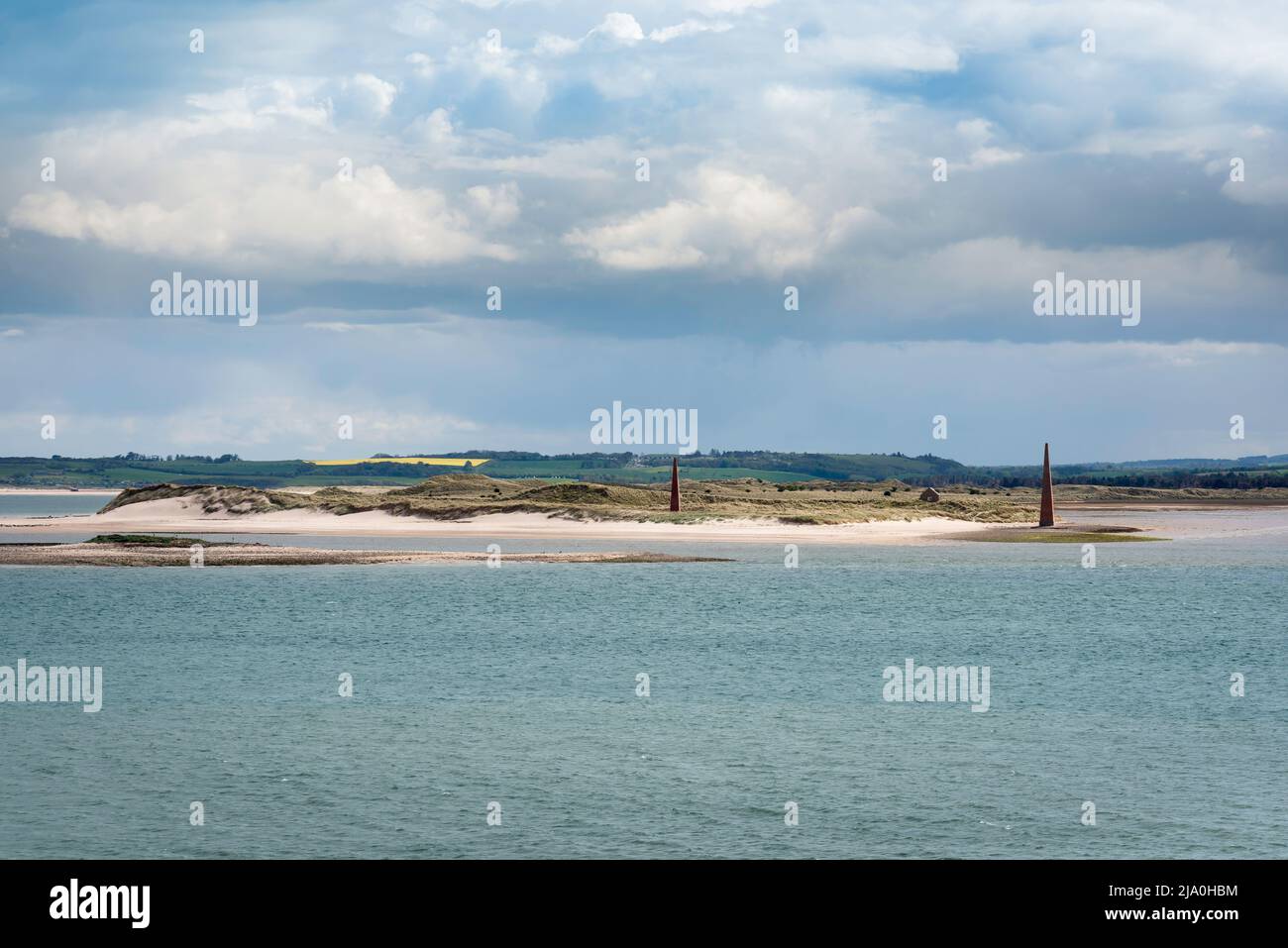 Guile Point Lighthouse, view of two stone clad obelisk towers sited on Guile Point, built to provide guidance for boats into Lindisfarne harbour, UK Stock Photo