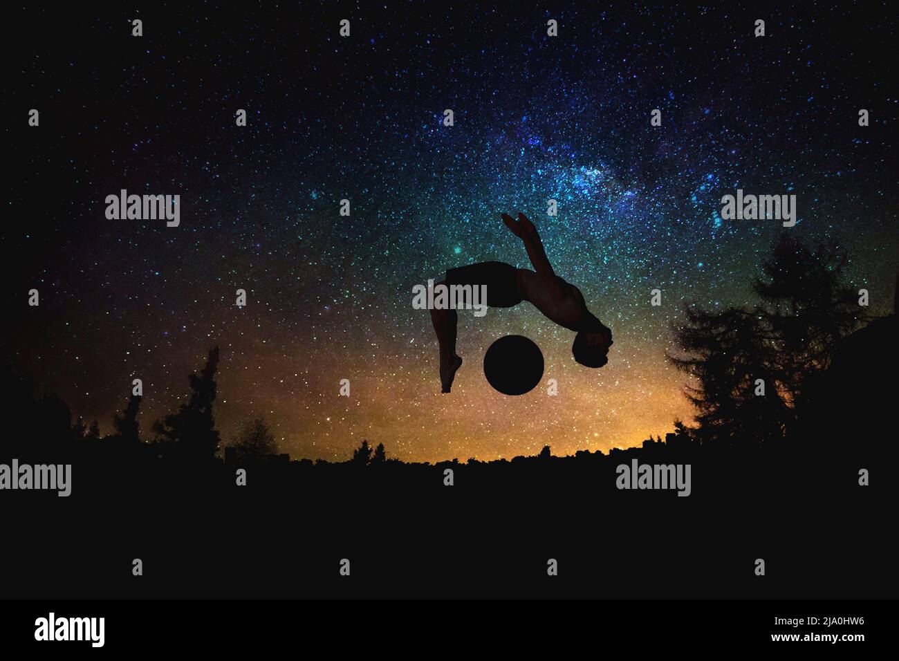 sporty man jumping silhouette at the night starry sky and moon background. Stock Photo