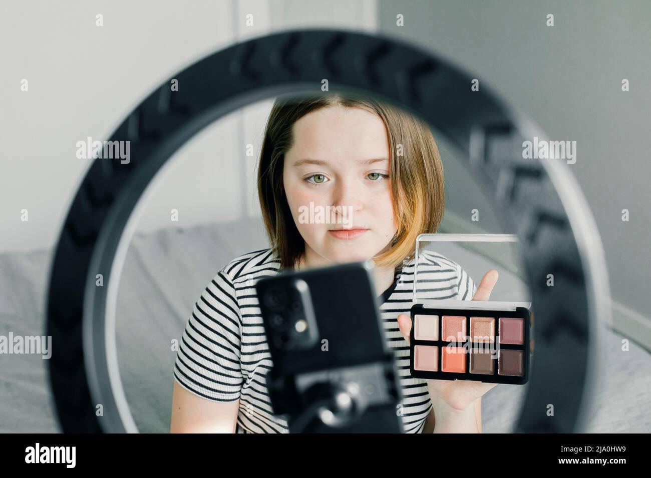 Teen girl blogger recording video for beauty blog. Blogging, videoblog, makeup concept. Stock Photo
