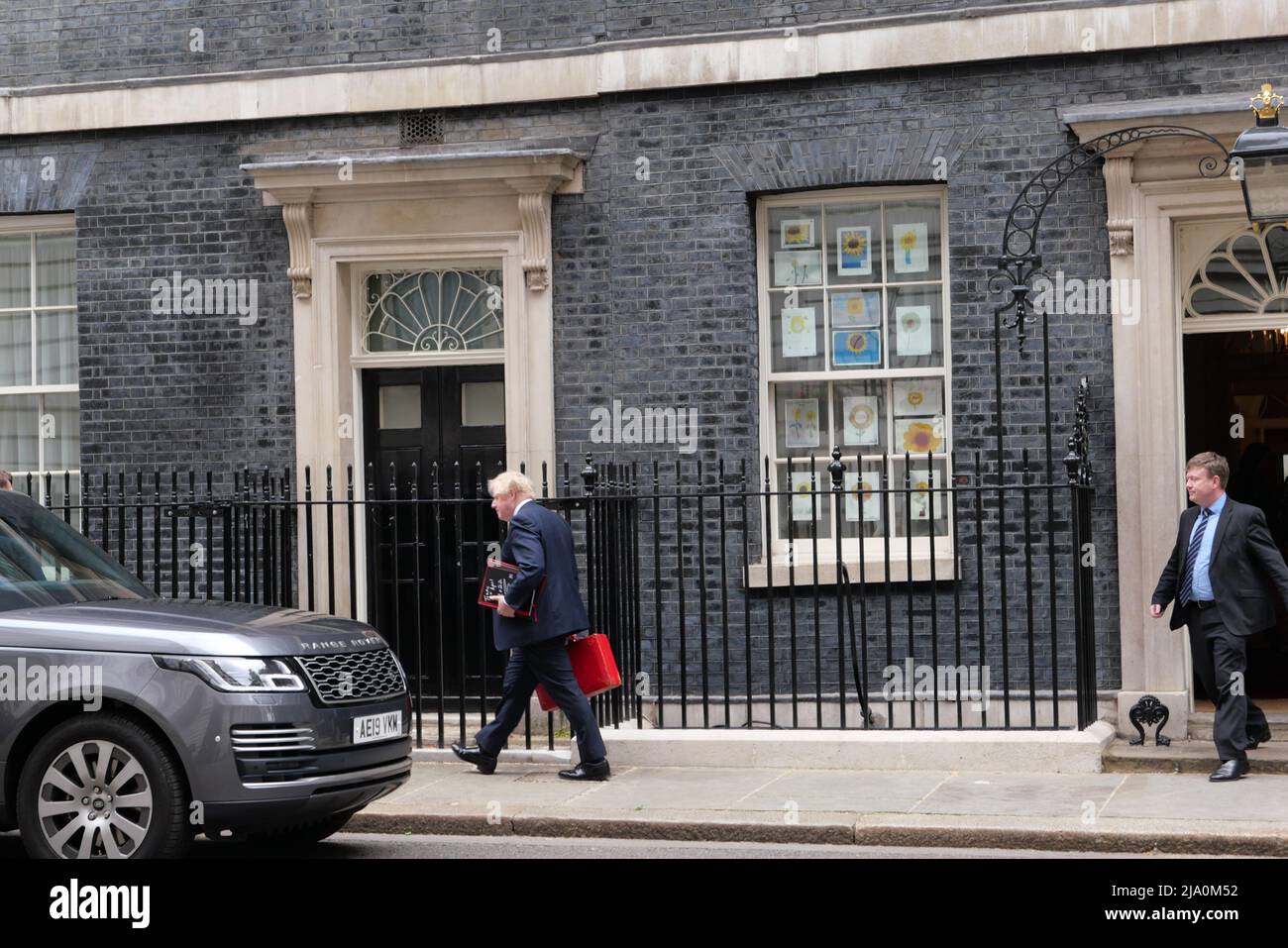 Boris Johnson leaves N10 with red briefcase today heading to Westminster as the Chancellor announces plans to give all households £400 of financial help as a grant to millions of people .It will be payed for by a windfall tax from energy companies making billions in profit  while millions of people in the UK are having to choose heating or eating as prices rise ..All households to get £400 in Autumn in a form off a grant that won't have to be repaid .Meanwhile Boris Johnson is getting pressure to quit over various parties held at N10 during  known as party gate after Sue Gray report . Stock Photo