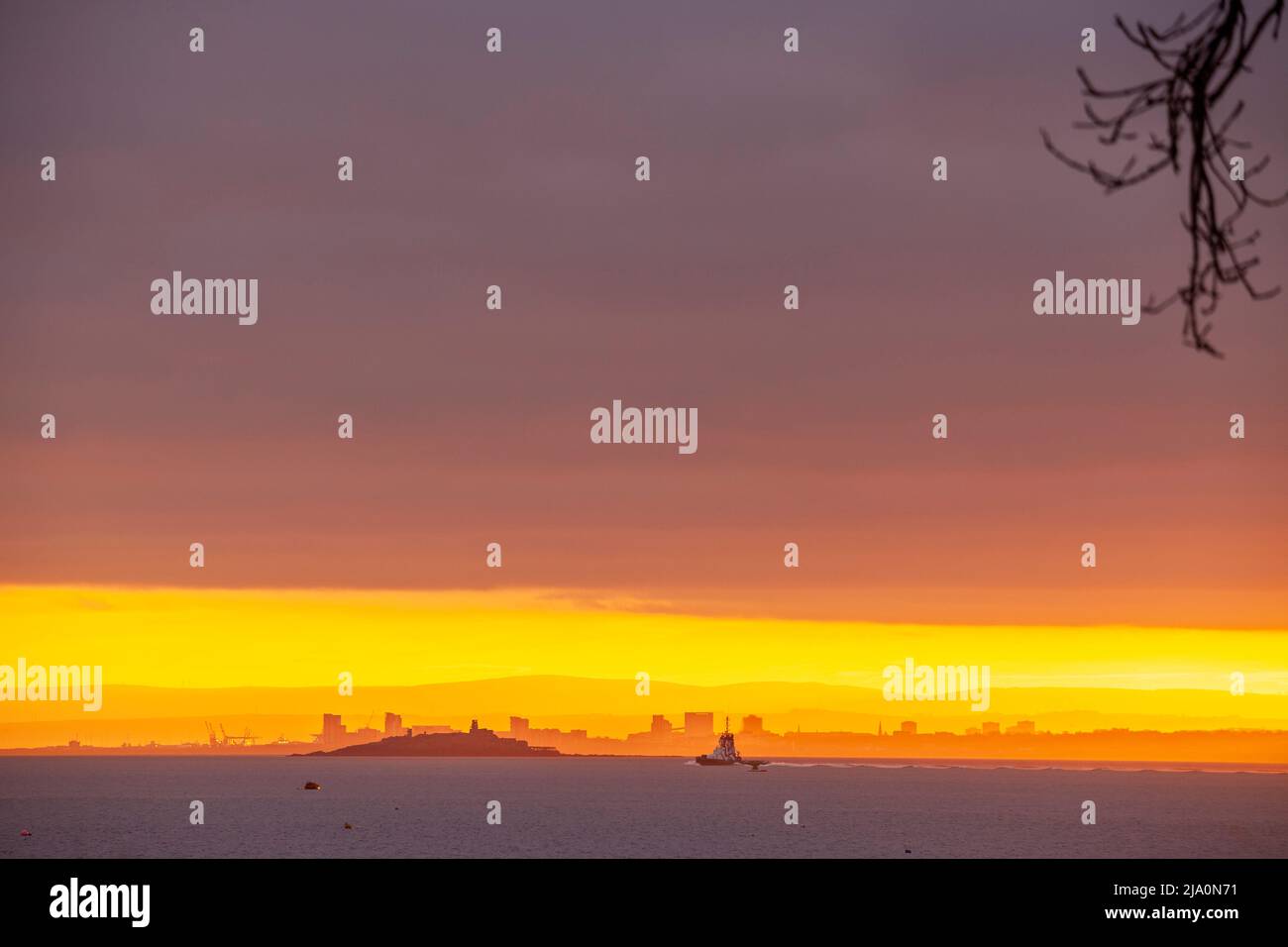 Inchmickery Island silhouetted by the sunrise over Edinburgh Stock Photo