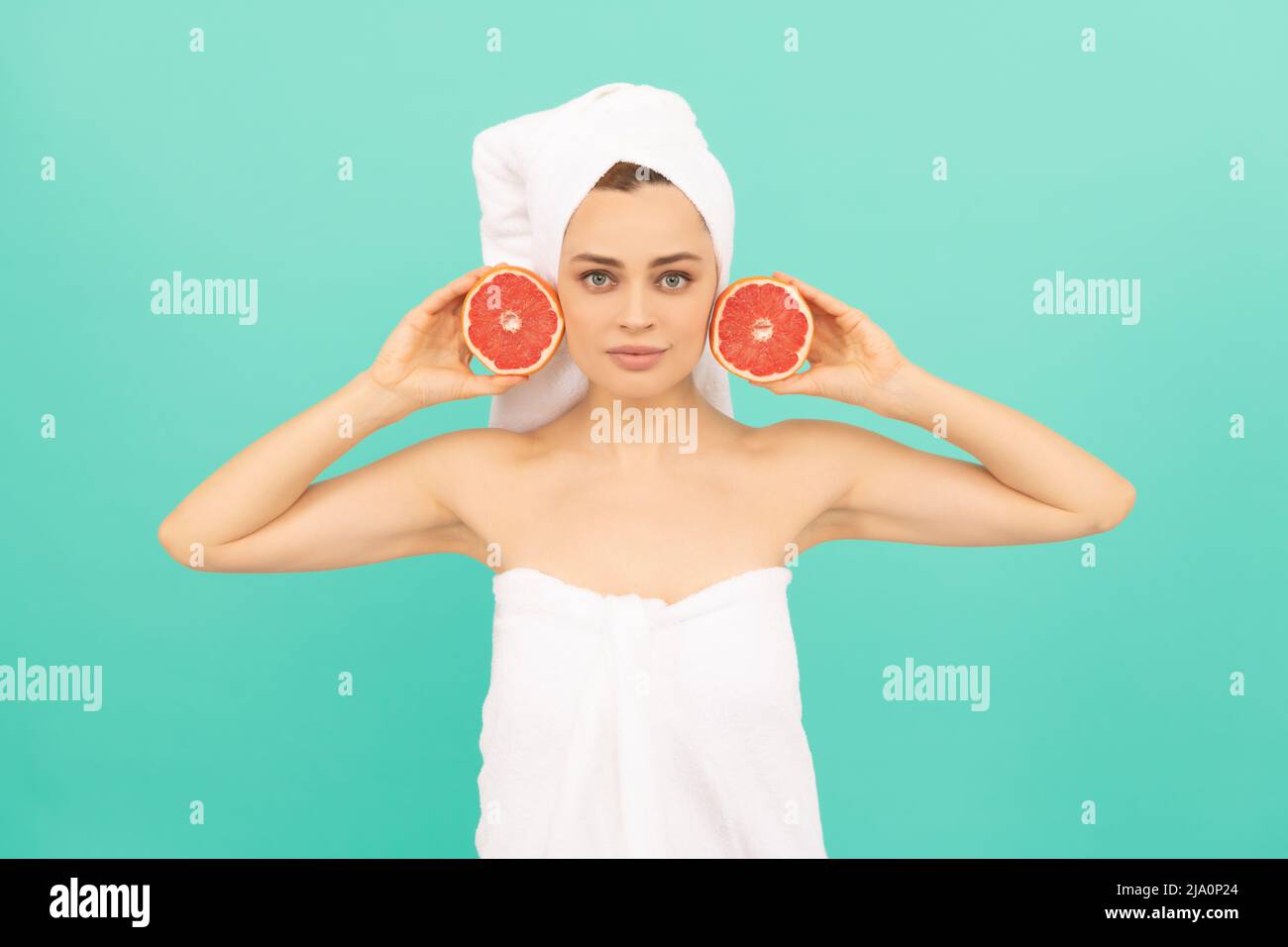 young girl in towel after shower with grapefruit on blue background