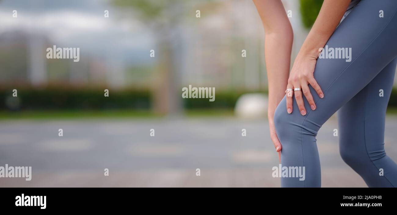 pain and from knee injury during morning run. Young woman