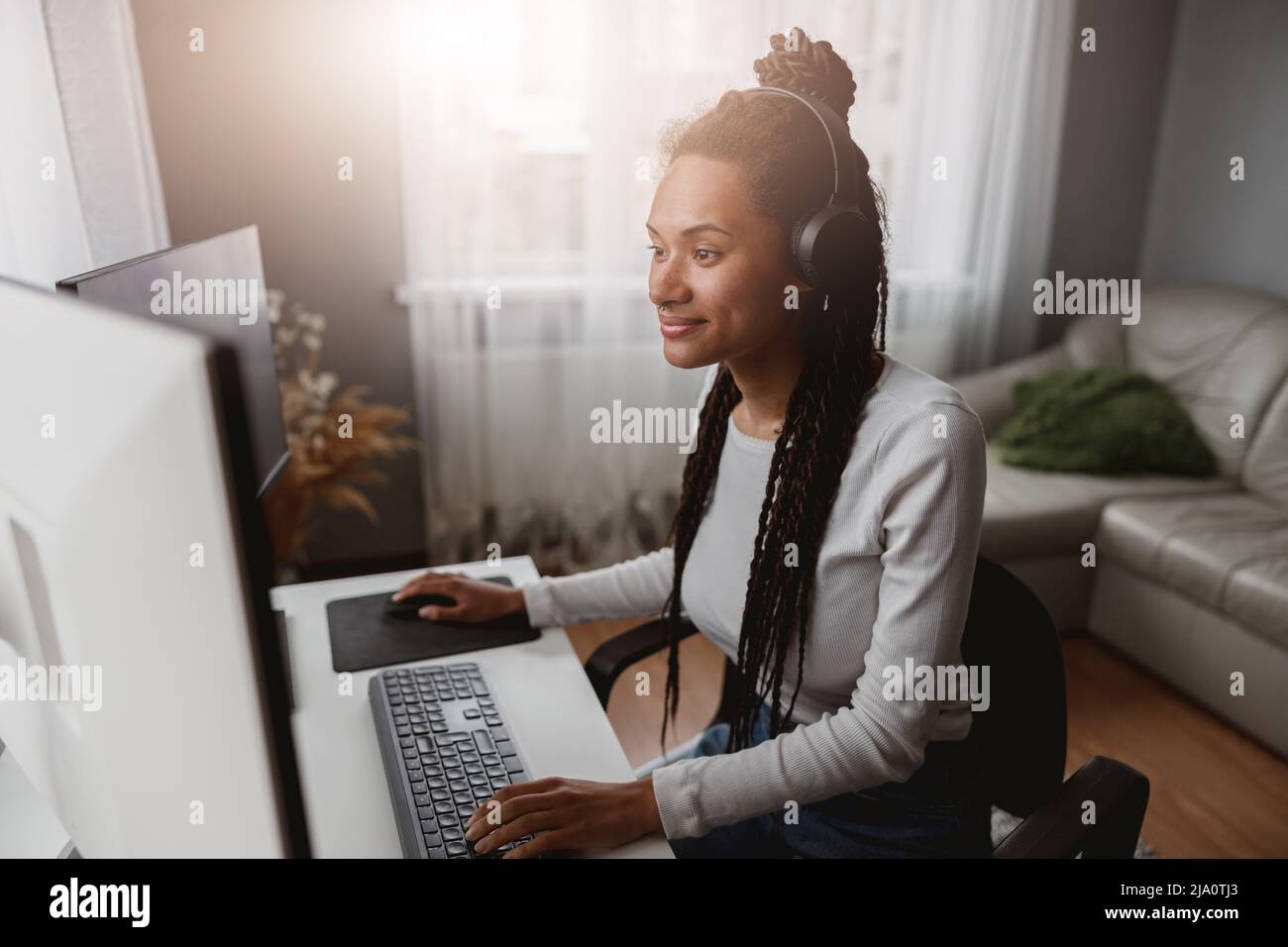 Portrait of smiled beautiful woman developer working indoor, stylish young female using computer Stock Photo
