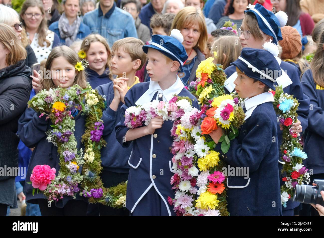 Bisley, Glos, UK. 26th May, 2022. Children from the Blue Coat school dressed in antique costumes are led through the village in a colourful procession. The tradition of dressing the wells in flowers was started in 1863 by the Vicar the Reverend Keble. The procession from the Church of England school takes place on Ascension Day each year. Credit: JMF News/Alamy Live News Stock Photo