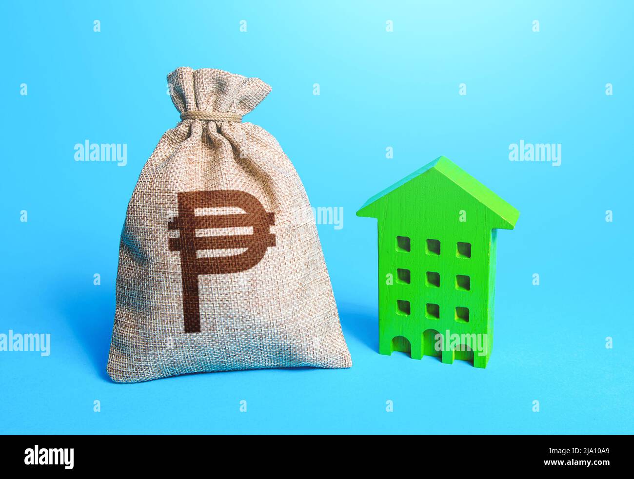 Philippine peso money bag and green Investments in sustainable housing. Investment in green technologies. Reduced emissions, improved energy efficienc Stock Photo