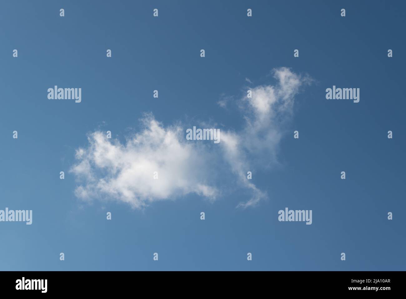 Cloud in blue sky, cloud in shape of fairy tale creature, dragon or bird Stock Photo