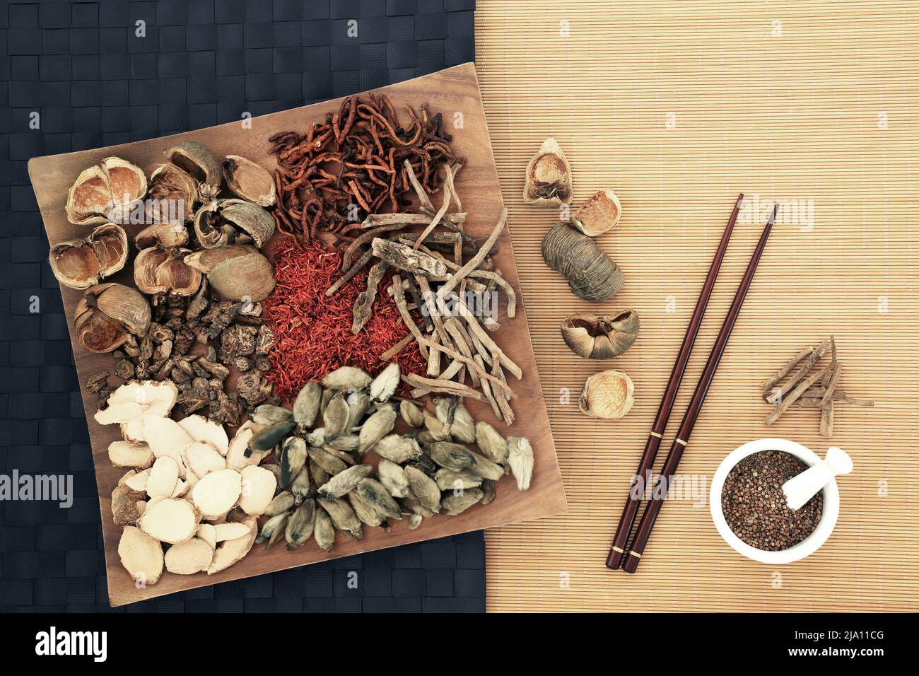 Traditional Chinese herbal plant medicine preparation with herbs and spice, chopsticks and mortar. Alternative natural holistic Asian healing remedy Stock Photo