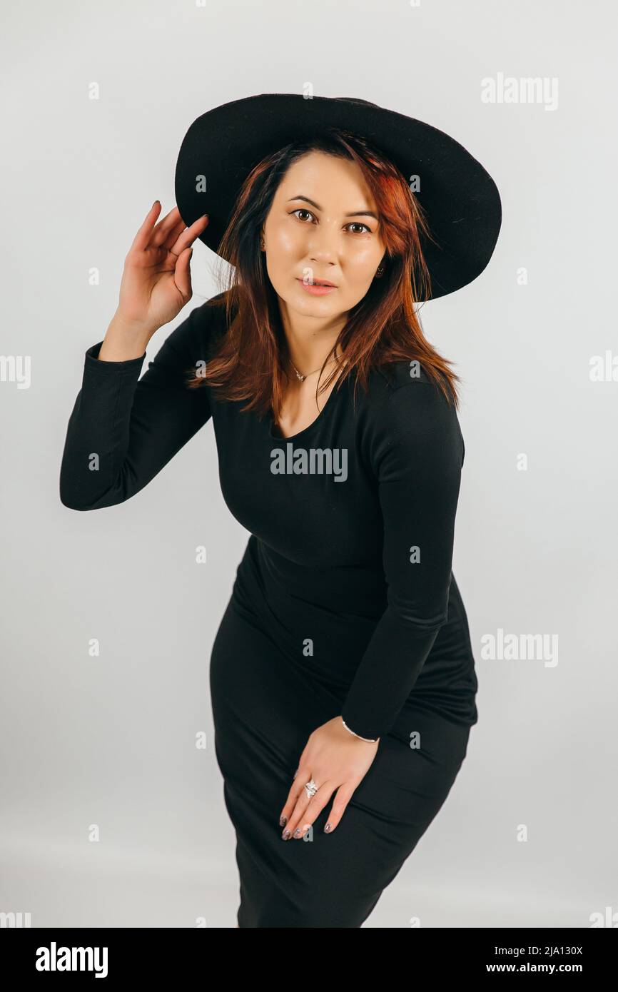 Pretty woman posing in studio Girl in a dress and hat Stock Photo - Alamy