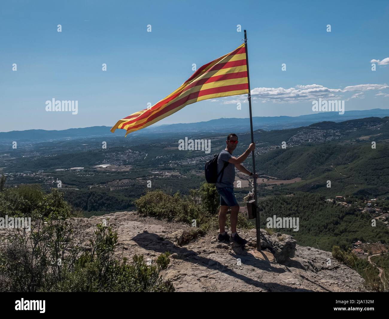 Man standing on top of a mountain holding a flag hi-res stock ...