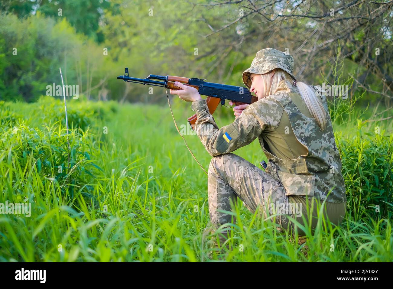 Ukrainian female soldier armed with an assault rifle patrols a combat zone Stock Photo