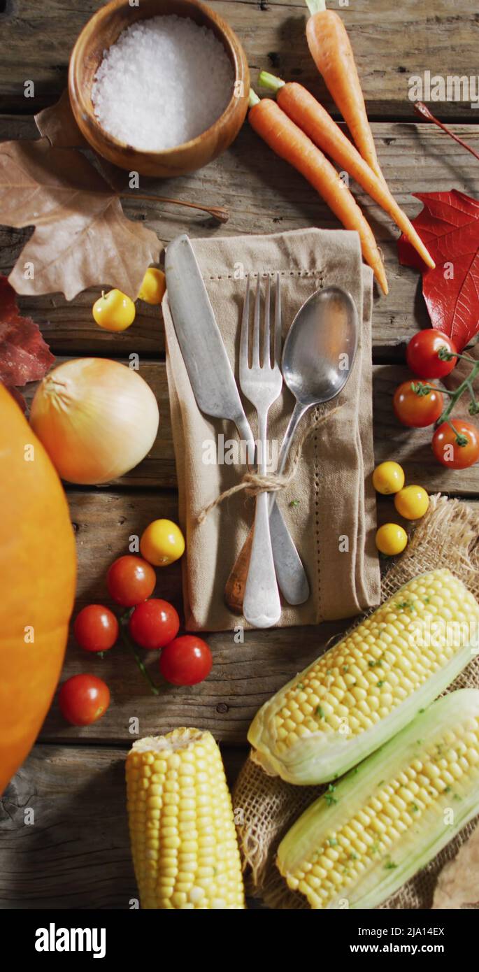 Vertical image of close of cutlery and halloween autumn produce on rustic background Stock Photo