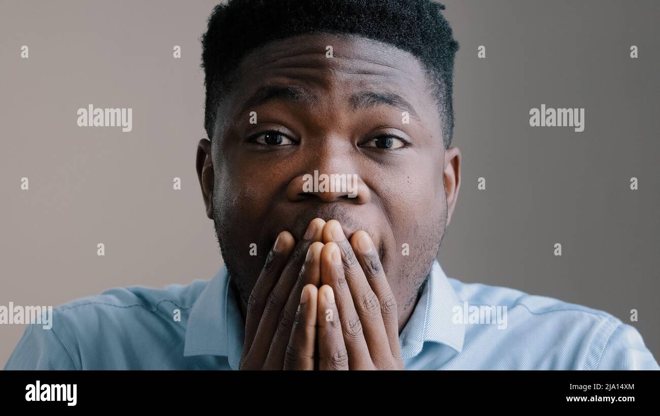 Shocked happy african american young boyfriend business man surprised look at camera rejoice good news amazed guy joyful male winner show wow reaction Stock Photo