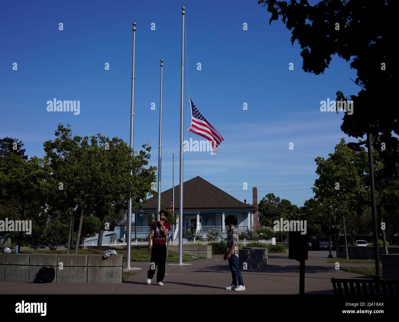 Millbrae, USA. 25th May, 2022. The U.S. flag flies at half-staff at a square in Millbrae, California, the United States, May 25, 2022. At least 19 children and two adults were killed in a shooting at Robb Elementary School in the town of Uvalde, Texas, on Tuesday. Credit: Li Jianguo/Xinhua/Alamy Live News Stock Photo