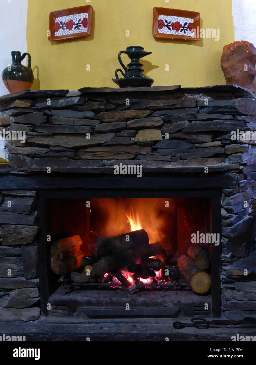 Traditional stone fireplace with burning logs Stock Photo - Alamy