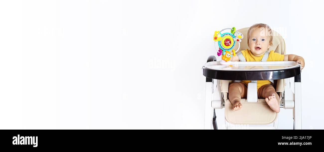 Cute caucasian infant girl ten months old sitting in baby chair and