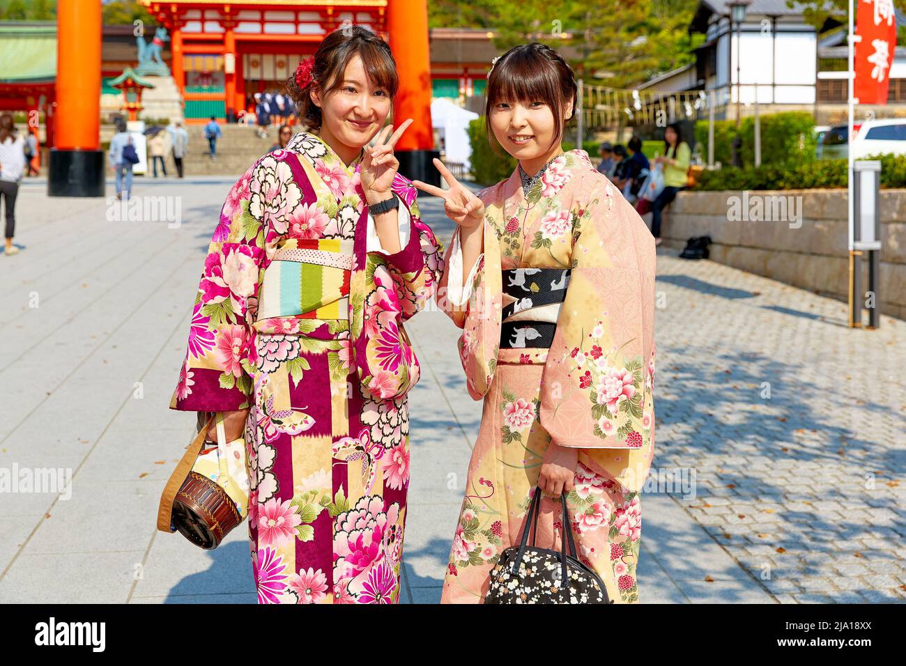 Japan. Kyoto. Fushimi Inari Taisha Shrine. Young smiling women dressed with traditional kimono Stock Photo