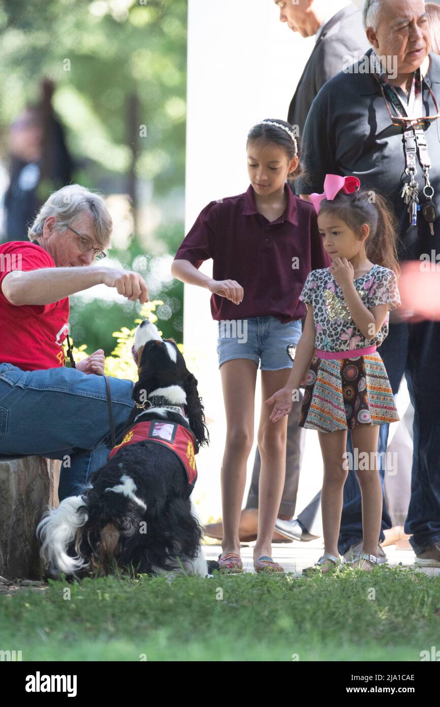Uvalde, United States. 26th May, 2022. Children play with a therapy dog outside the Civic Center in Uvalde, Texas where counselors are welcoming the public after Tuesday's mass shooting at Robb Elementary School. A gunman killed 19 children and two teachers. Credit: Bob Daemmrich/Alamy Live News Stock Photo