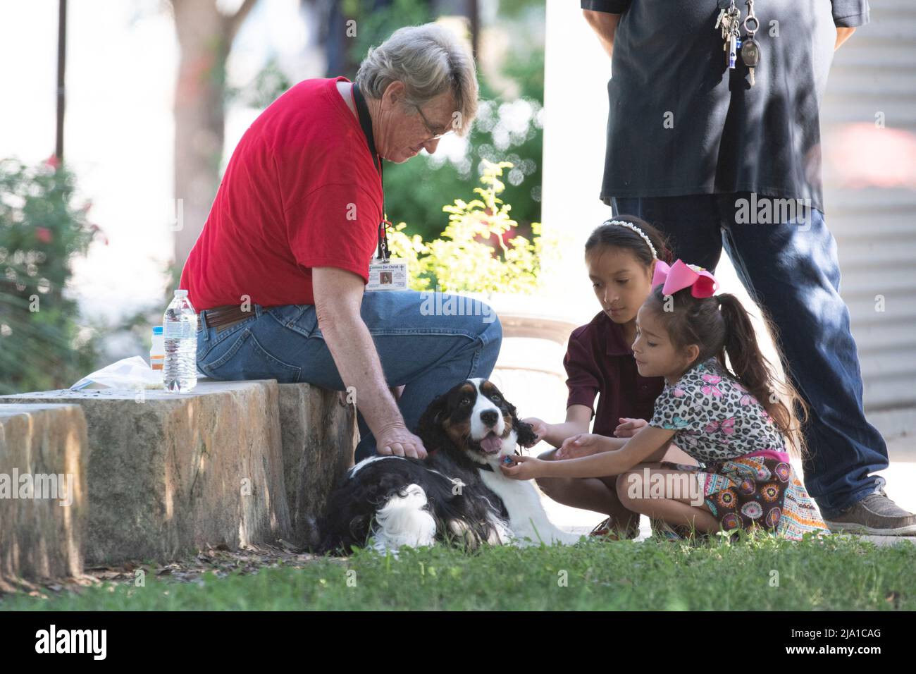 Uvalde, United States. 26th May, 2022. Children play with a therapy dog outside the Civic Center in Uvalde, Texas where counselors are welcoming the public after Tuesday's mass shooting at Robb Elementary School. A gunman killed 19 children and two teachers. Credit: Bob Daemmrich/Alamy Live News Stock Photo
