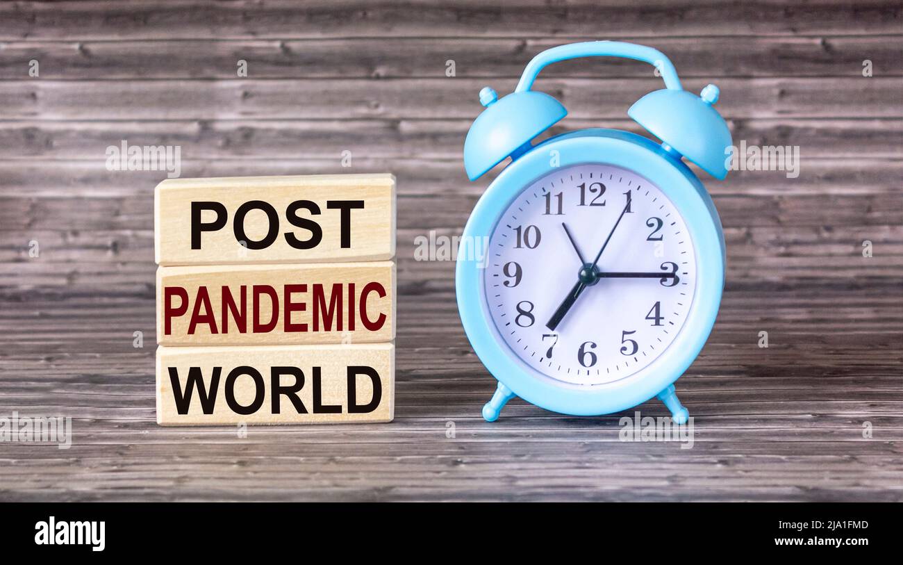 Wooden blocks form the words Post-pandemic world. Beautiful wooden background. Stock Photo