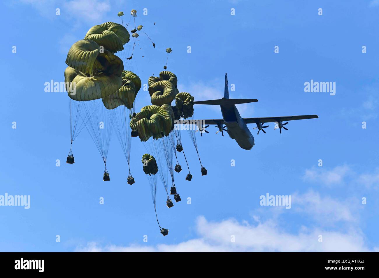 May 17, 2022 - Pordenone, Italy - U.S. Army paratroopers assigned to the Brigade Support Battalion, 173rd Airborne Brigade, release heavy drop packages with a U.S. Air Force 86th Air Wing C-130 Hercules aircraft onto Frida Drop Zone at Pordenone, Italy on May 17, 2022. The 173rd Airborne Brigade is the U.S. Army's Contingency Response Force in Europe, providing rapidly deployable forces to the USA European, African, and Central Command areas of responsibility. Forward deployed across Italy and Germany, the brigade routinely trains alongside NATO allies and partners to build partnerships and st Stock Photo