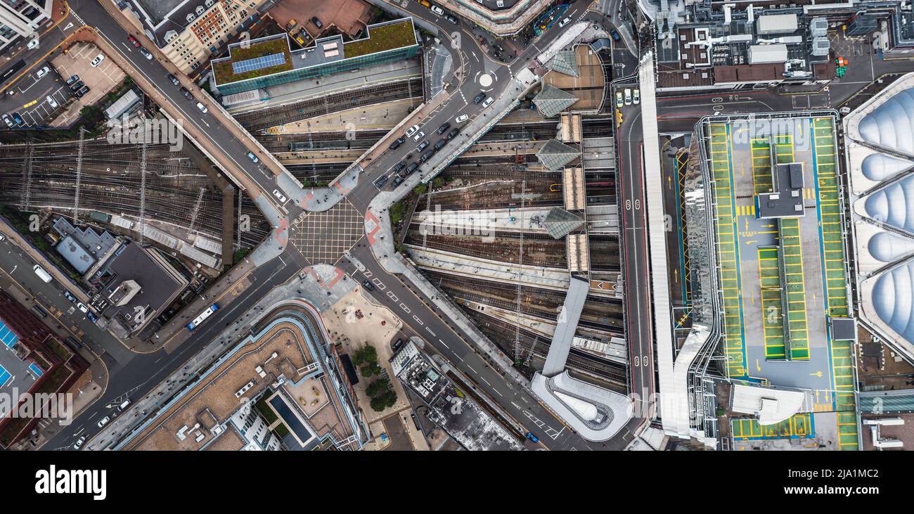 aerial view directly above an urban metropolis with crossroad street junction over busy subway and underground railway tracks at Birmingham New Street Stock Photo