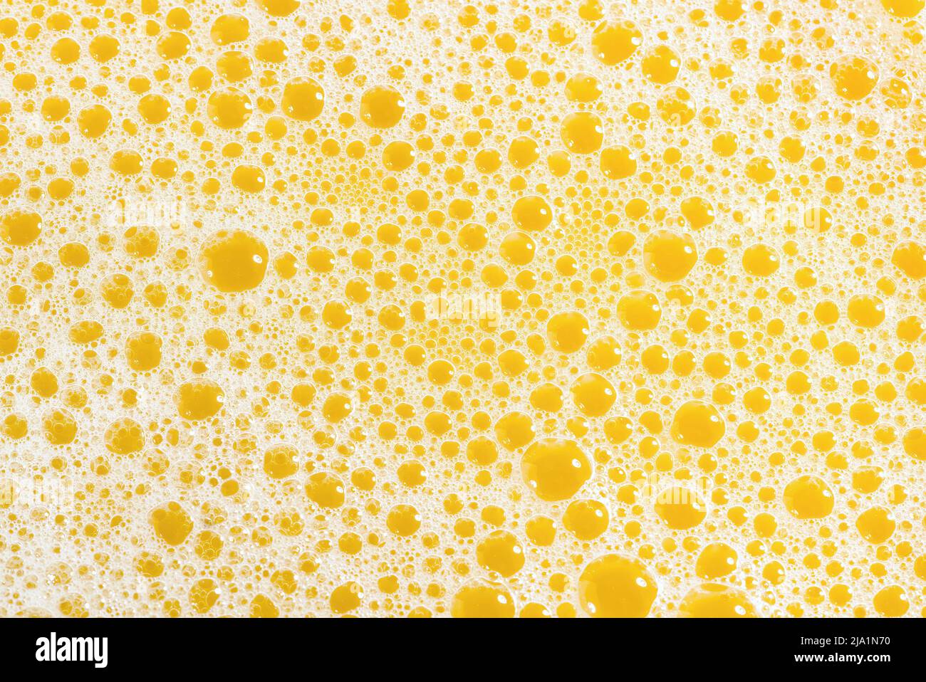 Closeup of orange juice foam, top view. Splash of fresh sweet orange