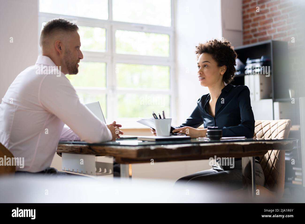 Mature Businesswoman Taking An Interview Of Man Over The Wooden Desk In ...