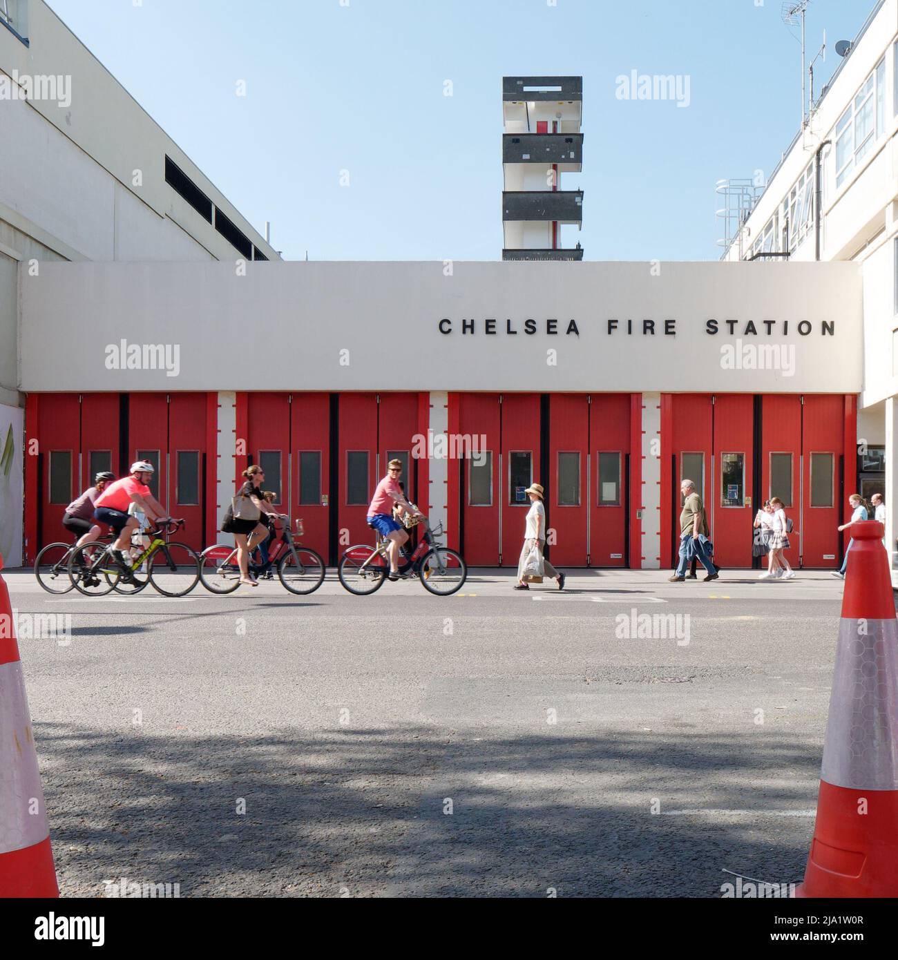 London, Greater London, England, May 14 2022: Cyclists and pedestrians pass by Chelsea Fire Station on The Kings Road. Stock Photo