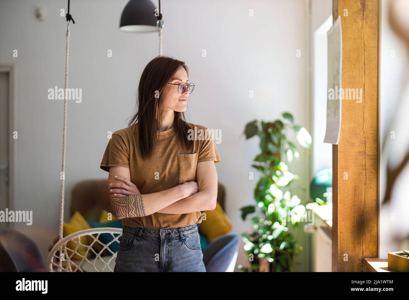 Portrait of a young woman standing in her home Stock Photo - Alamy