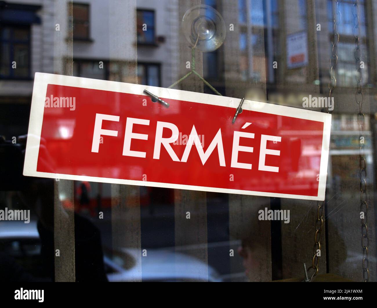 Closed sign in a shop window written in French (translation: Closed ...