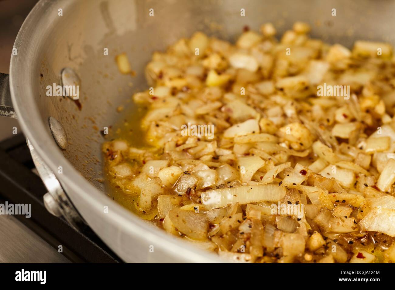 Onions caramelizing in a steel skillet Stock Photo Alamy