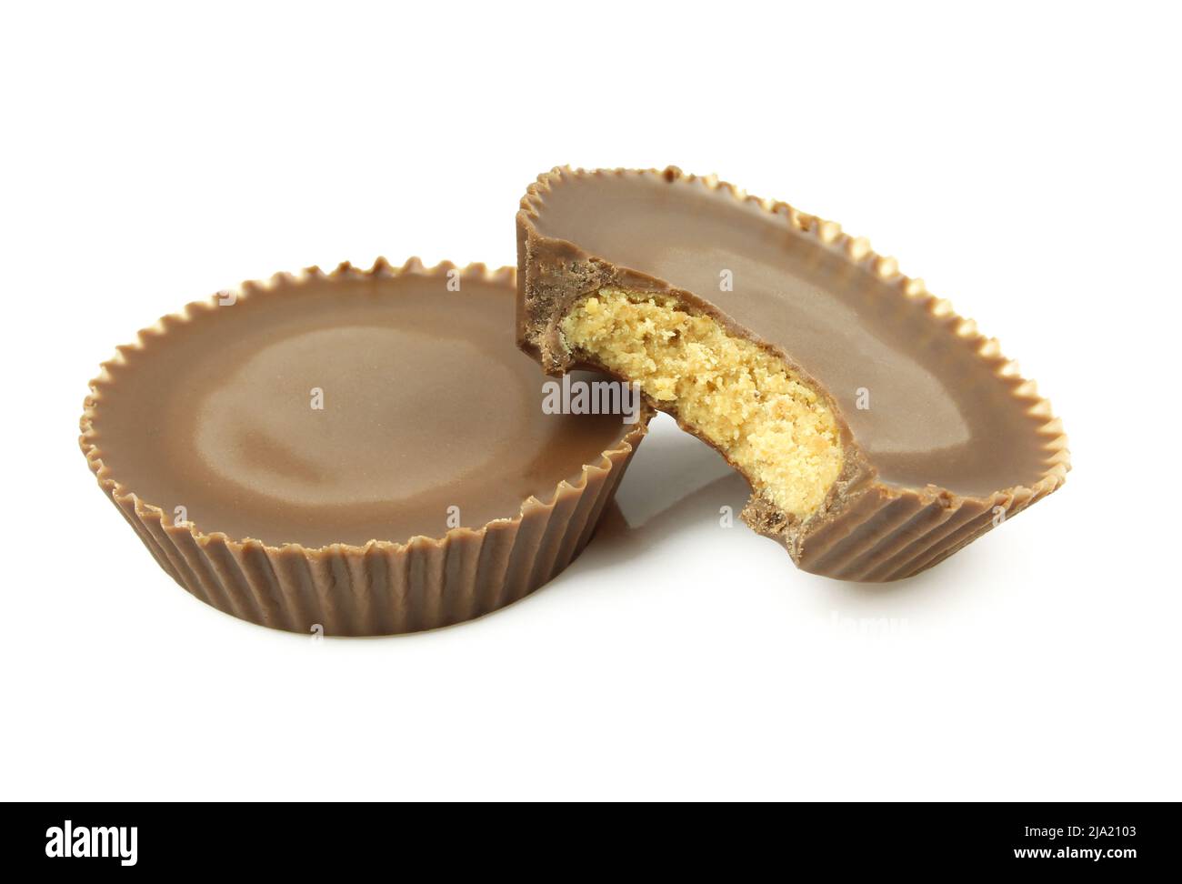 Short cupcake shaped sweets with peanut filling and chocolate cover. Bitten and isolated on white background Stock Photo