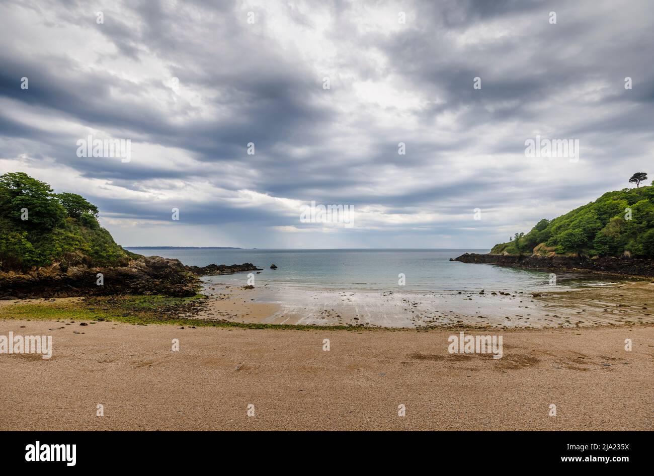 Panoramic view of Fermain Bay at low tide, St Peter Port, east coast of Guernsey, Channel Islands, dark clouds before a heavy rain storm and downpour Stock Photo
