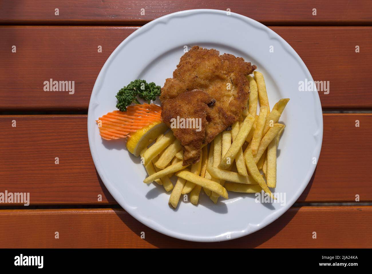 Schnitzel Viennese style served with french fries in a garden restaurant, Franconia, Bavaria, Germany Stock Photo