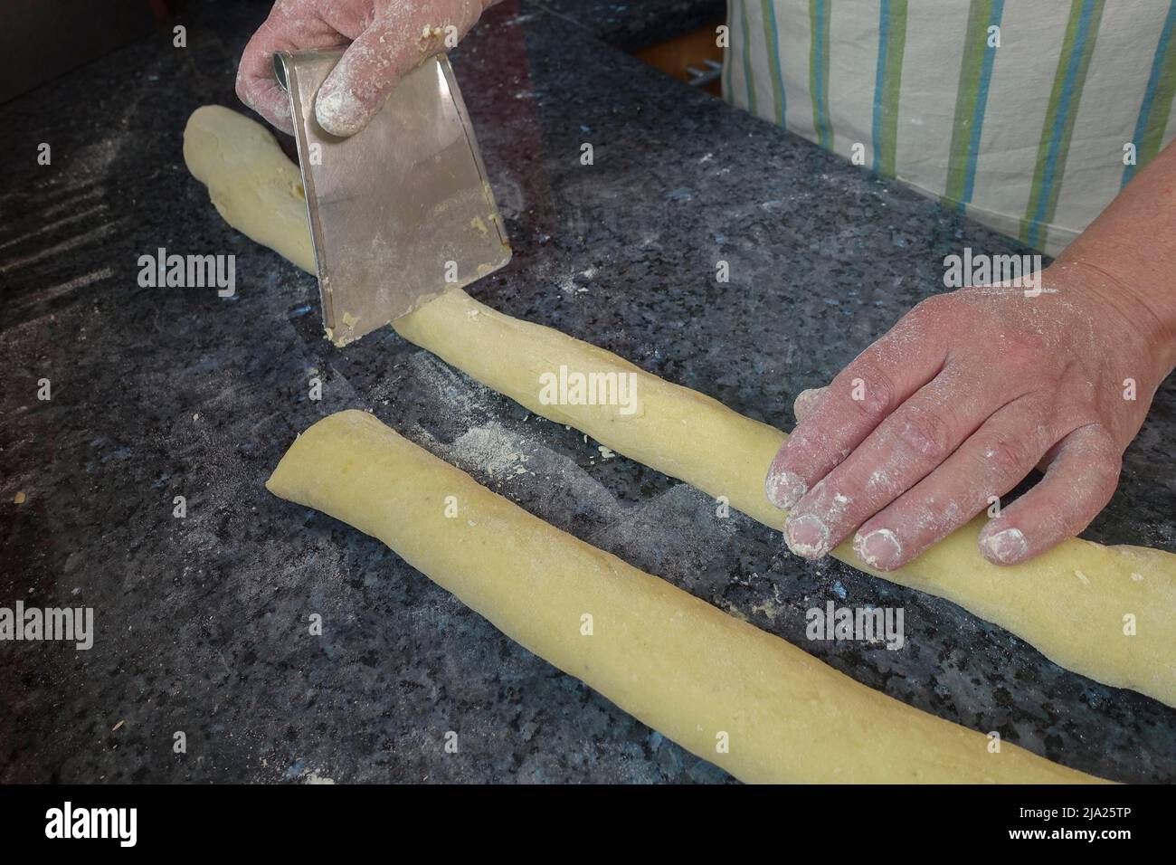https://c8.alamy.com/comp/2JA25TP/swabian-cuisine-preparing-bruckhoelzer-schlanganger-sperrknechte-made-of-potato-dough-dividing-dough-rolls-portioning-dough-scraper-making-2JA25TP.jpg