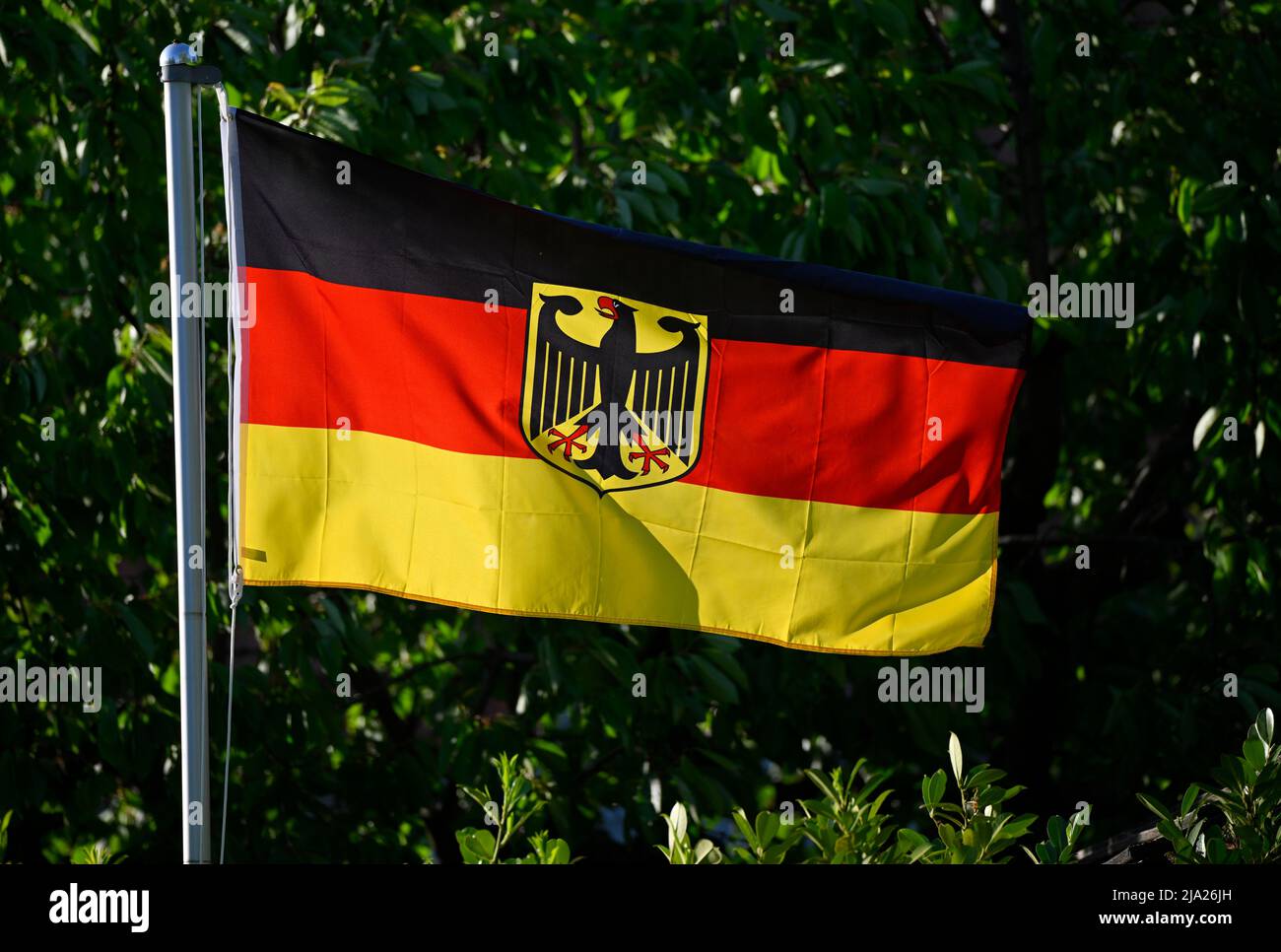 German flag with federal eagle on flagpole, Stuttgart, Baden-Wuerttemberg, Germany Stock Photo