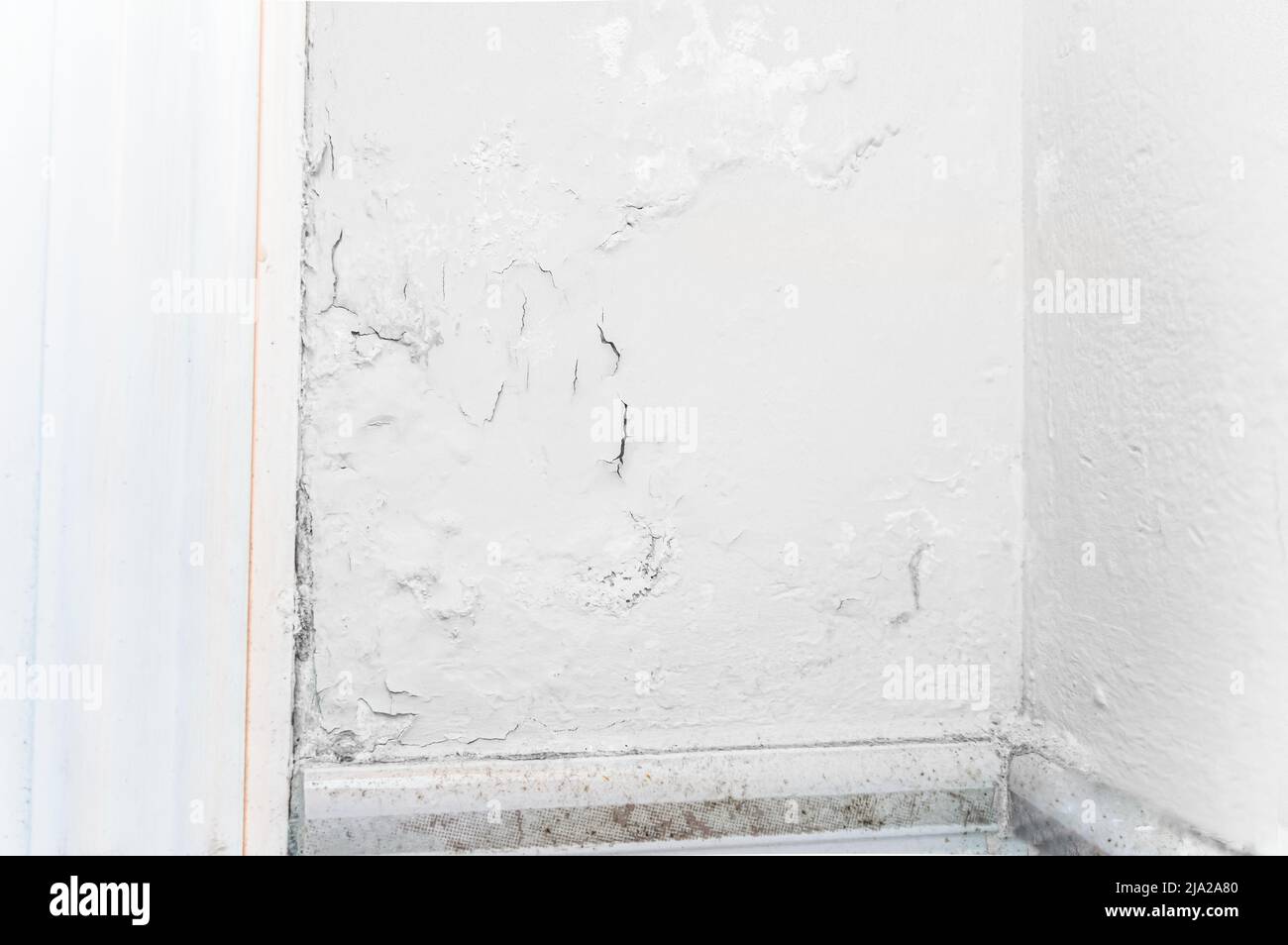 Peeling wall paint, moist damp texture on house wall with some water stain and leaks Stock Photo