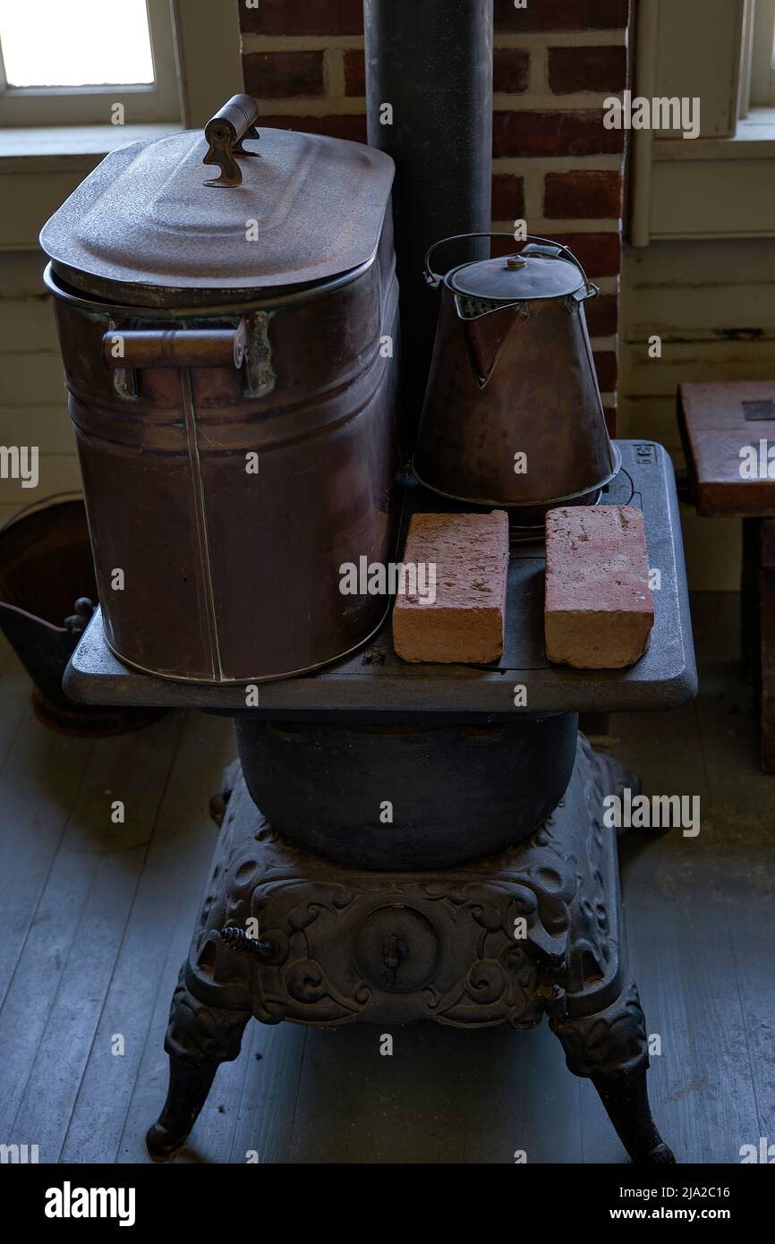 A cast iron coal stove is seen  in a rustic setting. Stock Photo