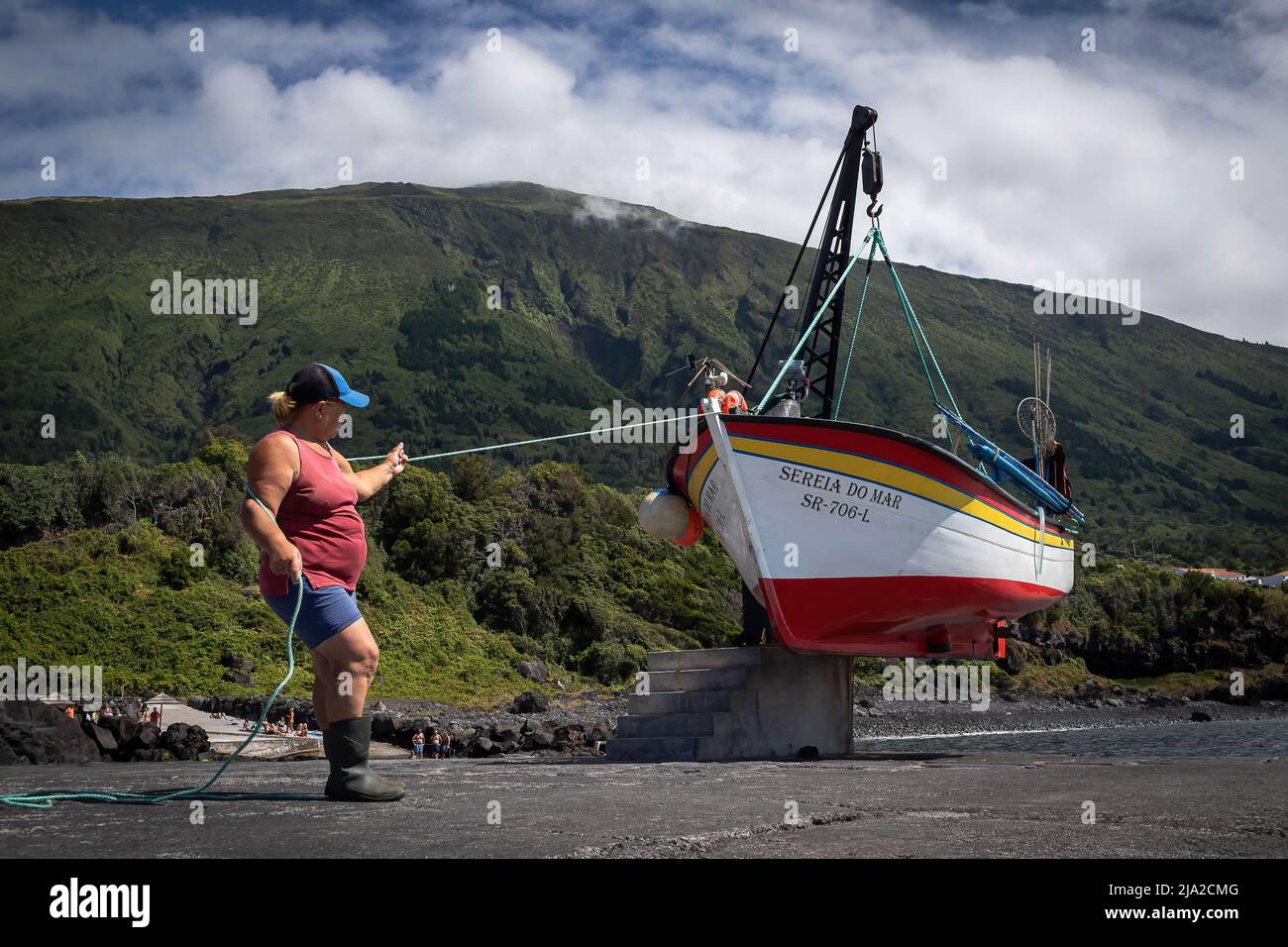 Portugal. 16th Aug, 2021. At the end of another fishing session, a fisherwoman pulls the boat into the port of S. Caetano, on the island of Pico. Women are well present in the fishing industry in the Azores islands, but only a few venture to the sea. Mostly work on land preparing baits and nets and cleaning or selling fish. Today, there are only five fisherwomen that go into the sea, making them probably the last fisherwomen in the archipelago. (Photo by Eduardo Leal/SOPA Images/Sipa USA) Credit: Sipa USA/Alamy Live News Stock Photo