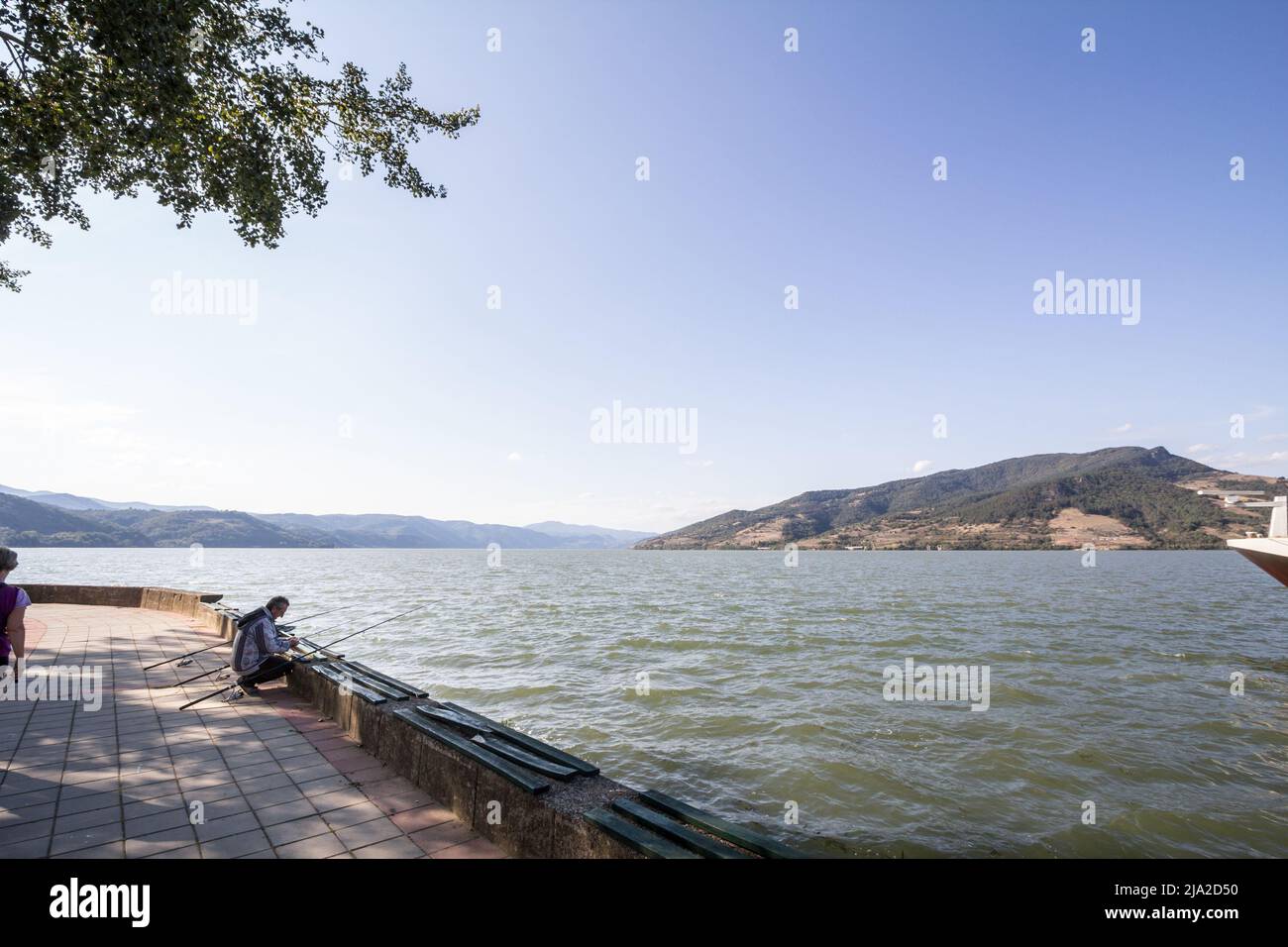 Picture of two men fishing in the Serbian city of Donji Milanovac on the Danube river, The city is located in the Danube gorges, also known as iron ga Stock Photo